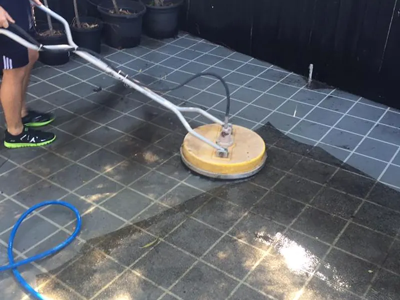 Rotary surface cleaner restoring a tiled outdoor area