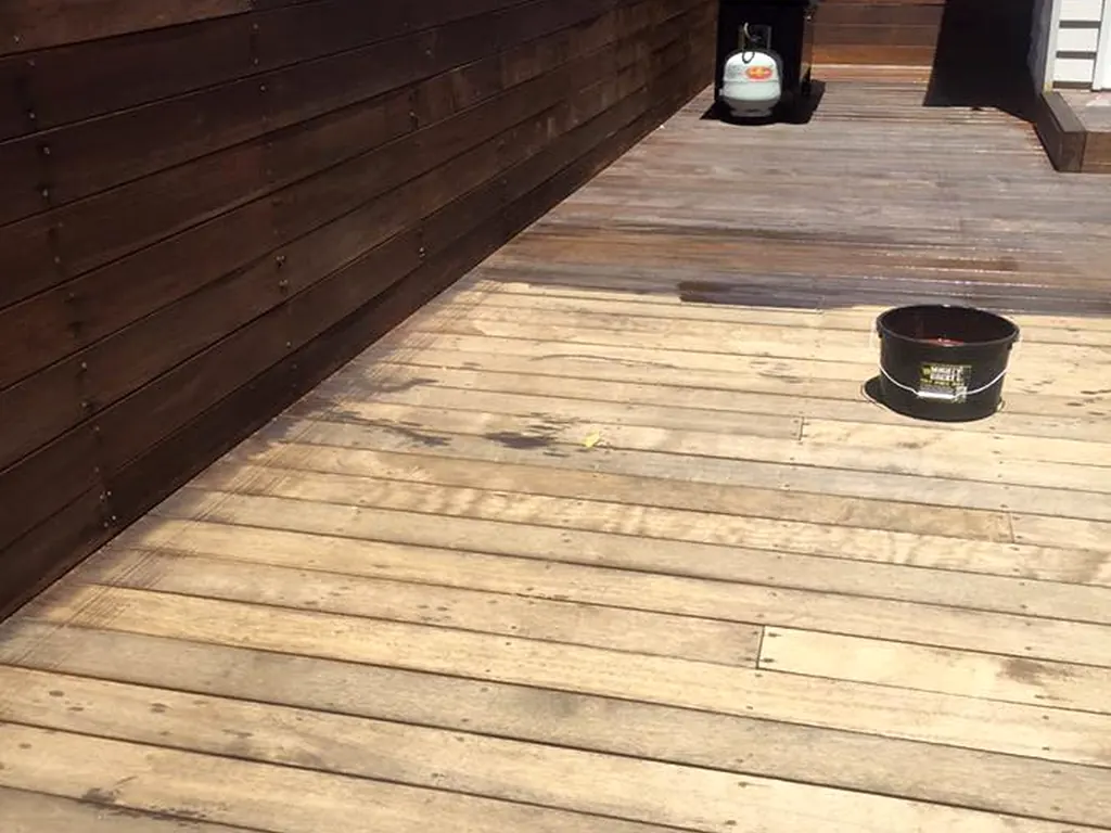Timber deck staining in progress beside weathered boards