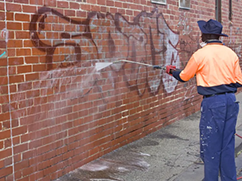 Professional graffiti removal from a commercial brick wall