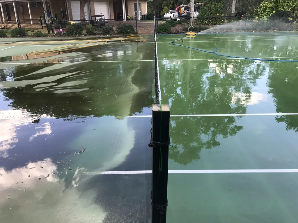 Professional surface-cleaning equipment washing a Brisbane tennis court