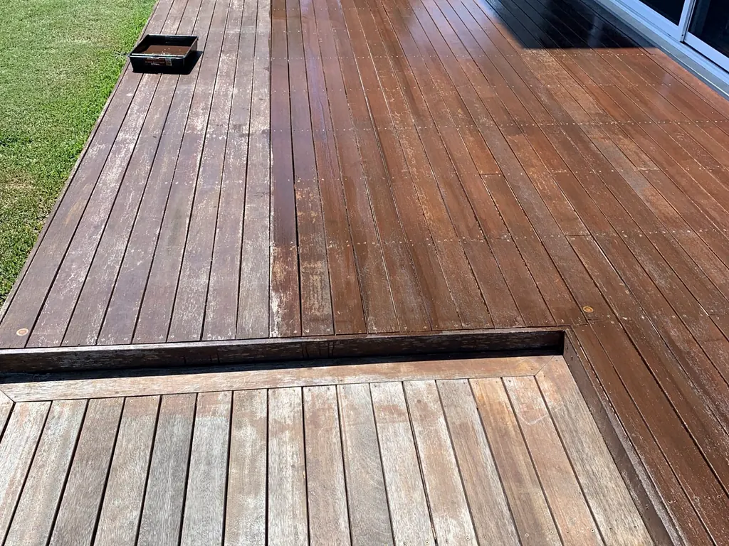 Before and after progress across a weathered timber deck