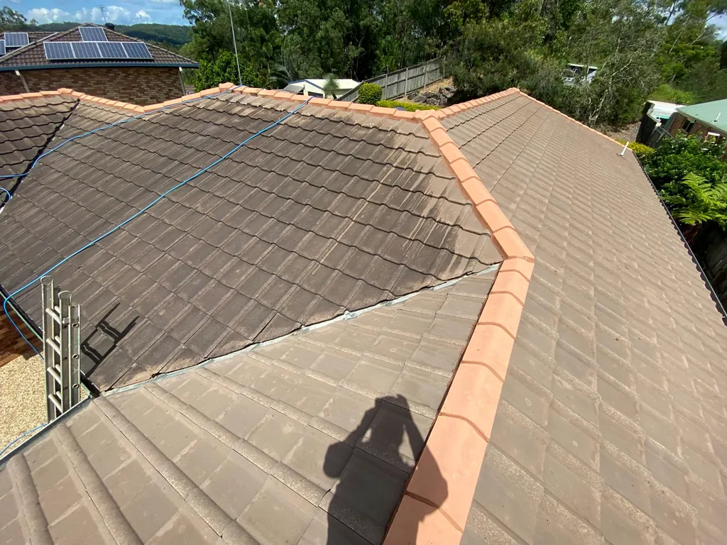 Roof cleaning progress around tiled ridges and valleys