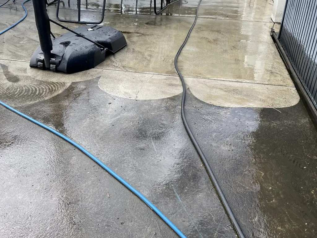 Long concrete driveway being pressure cleaned