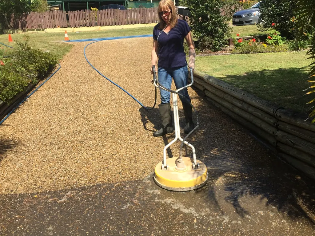 Driveway being pressure cleaned outside a family home