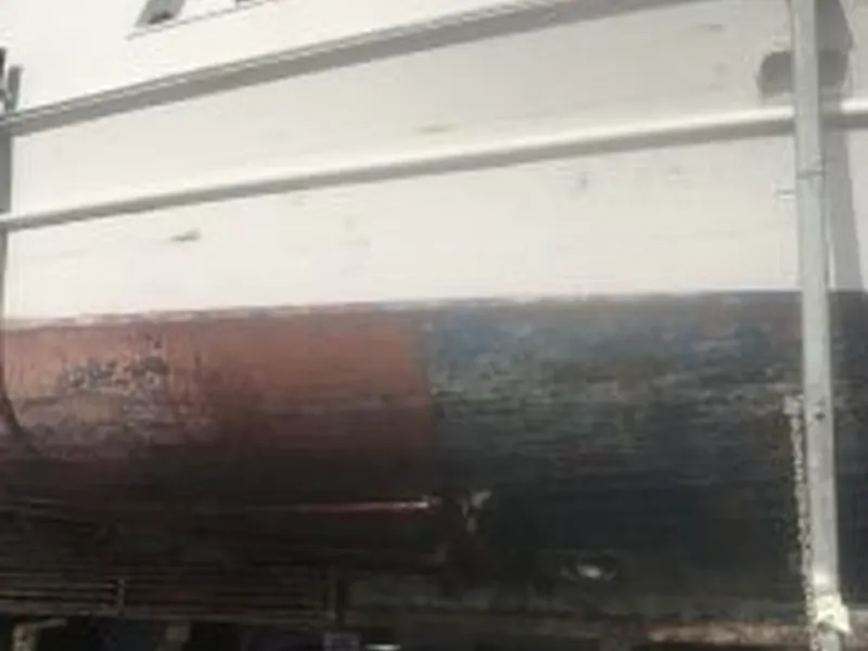 Boat hull cleaning in progress at a marine facility